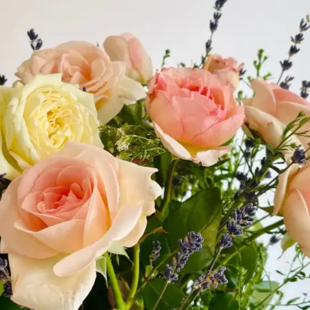Arrangement floral de tiges de rose fraiches et de tiges de lavande bleue.